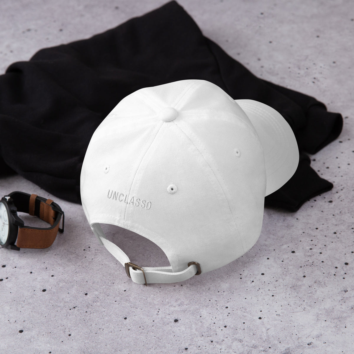Adjustable strap with metal buckle on white dad hat