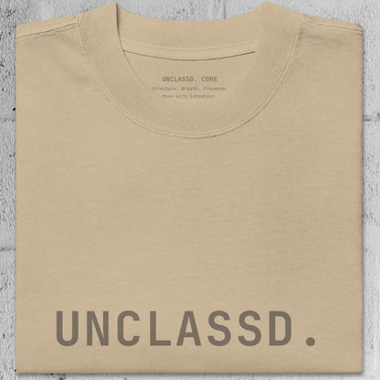 Close-up of faded khaki/beige heavyweight 240gsm cotton texture from the UNCLASSD CORE Oversized Tee, garment-dyed surface.