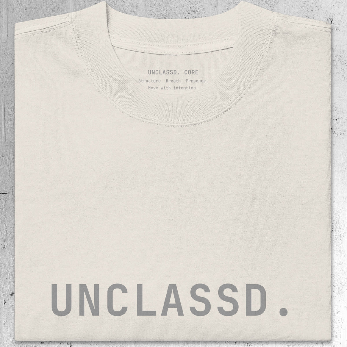 Tonal “UNCLASSD.” chest print detail on the CORE Oversized Tee in Bone color.
