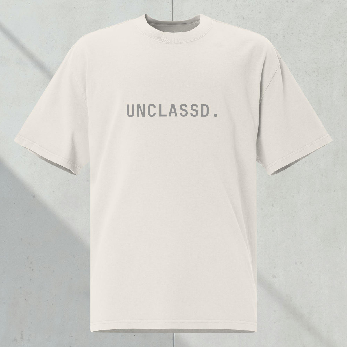 Front view of the UNCLASSD CORE Oversized Tee, bone color,  heavyweight 240gsm cotton, tonal chest print, boxy silhouette.