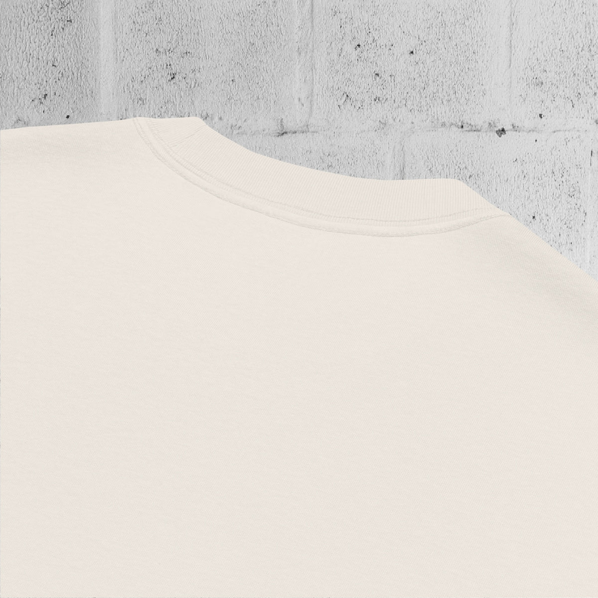 Close-up of wide ribbed neckline on the UNCLASSD CORE Oversized Tee, bone color, showing construction and finish.
